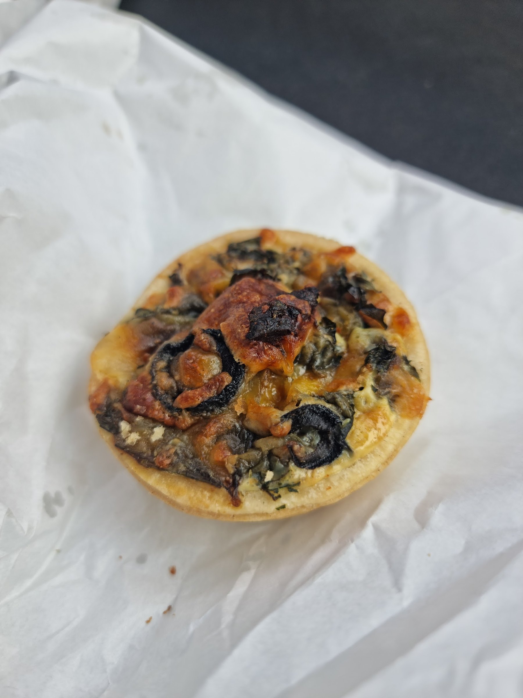 A spinach quiche on white paper